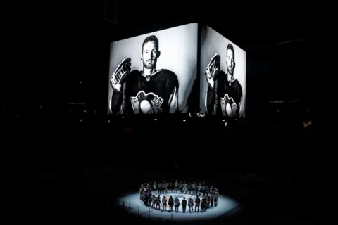 Reuters A picture of Johnson in black and white on a big screen with a circle of ice hockey players in a spotlight below. Taken at Pittsburgh, Pennsylvania, USA.