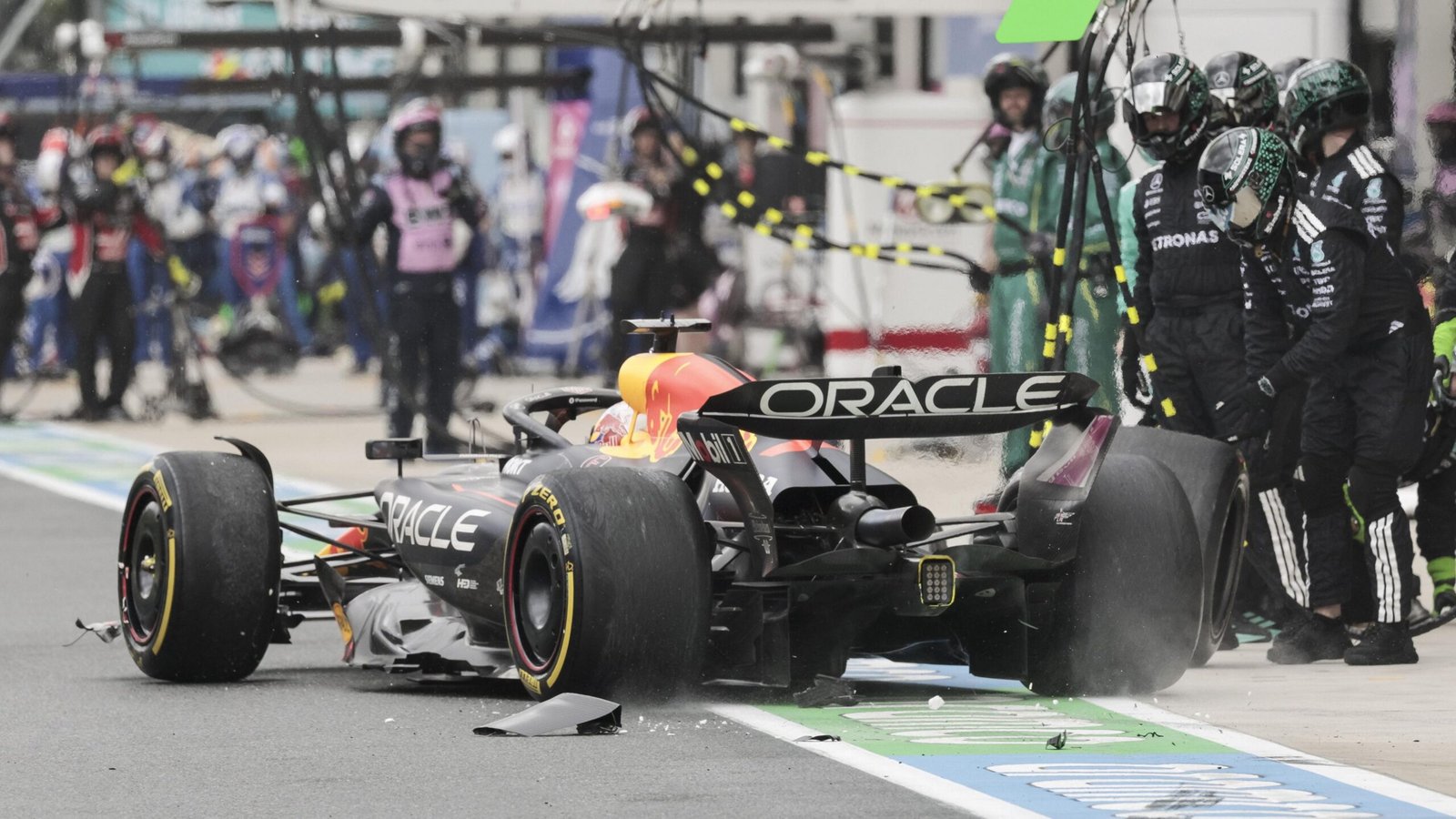 Debris falls off Max Verstappen's Red Bull in the pit lane