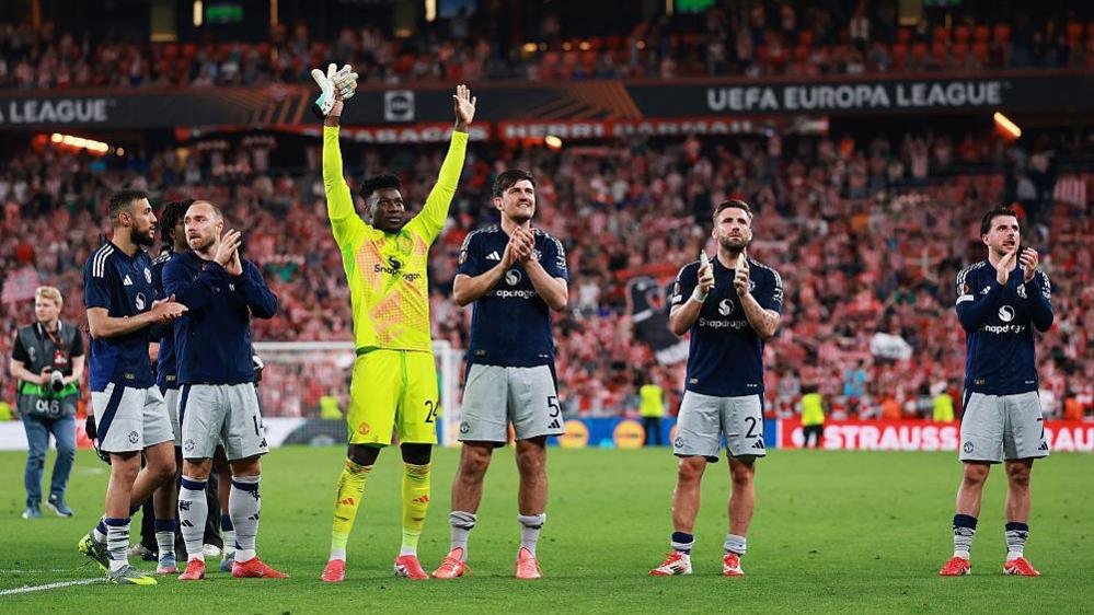 Manchester United players applaud the fans