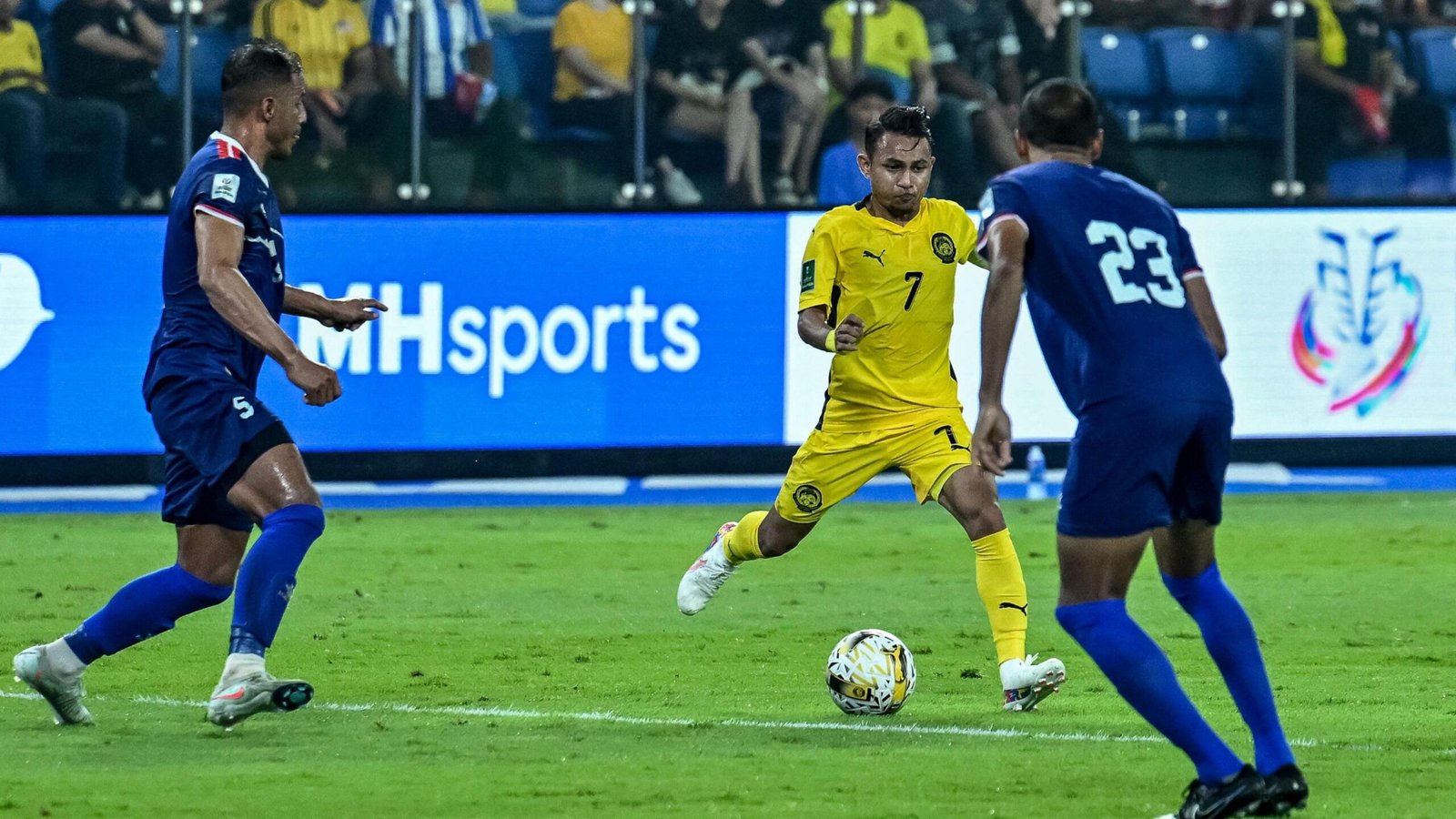 Malaysia national team player Faisal Halim, who was severely injured in an acid attack, dribbles past Nepal players during the Asian Cup qualifiers.