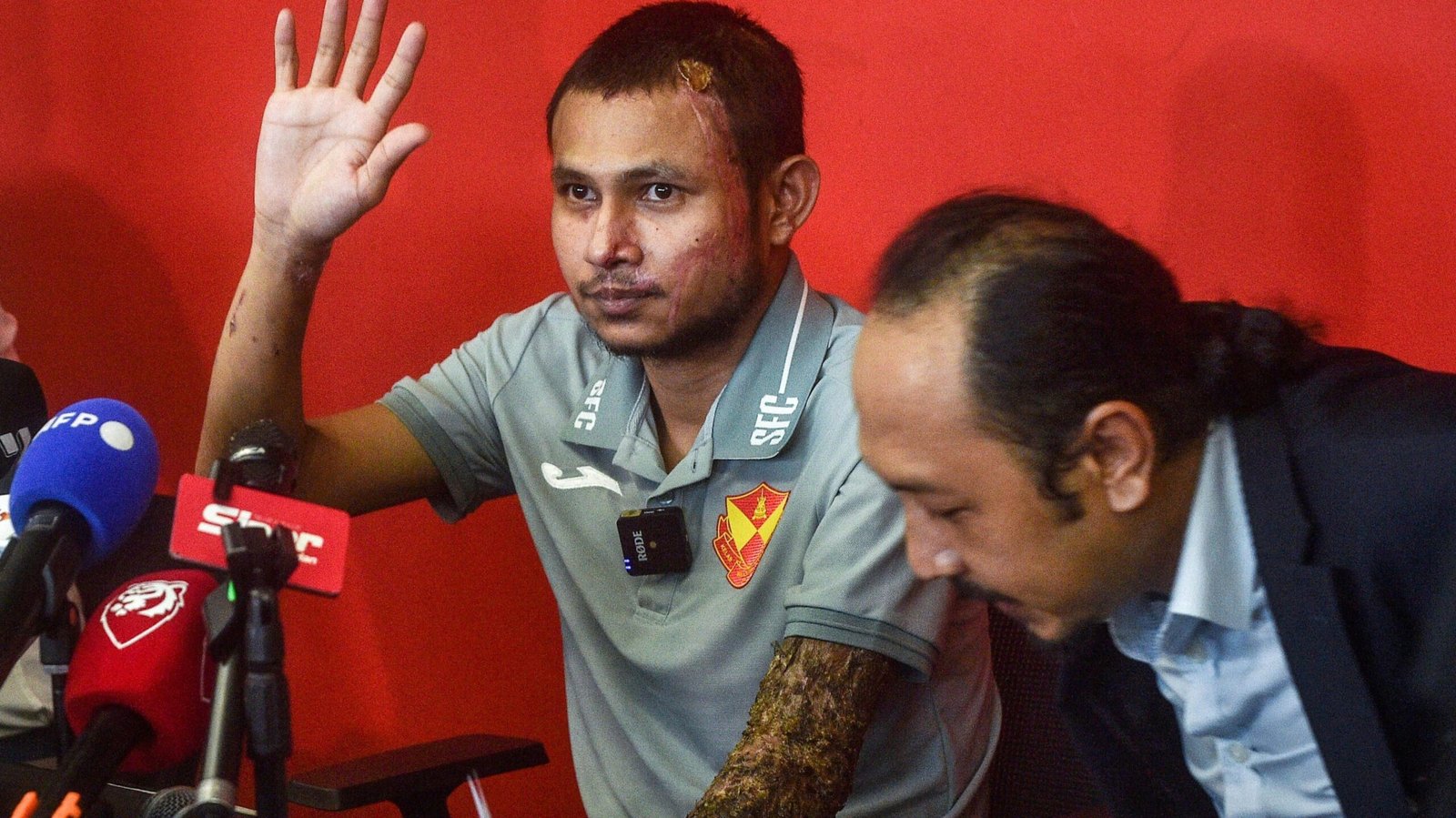 Malaysian national team and Selangor FC player Faisal Halim, who was severely injured in an acid attack, waves after a press conference in Shah Alam in Selangor on June 13, 2024
